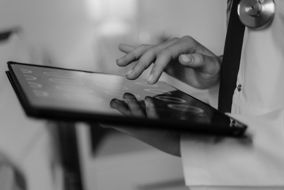 Close-up of a doctor's hand using a touchscreen tablet, highlighting digital healthcare technology
