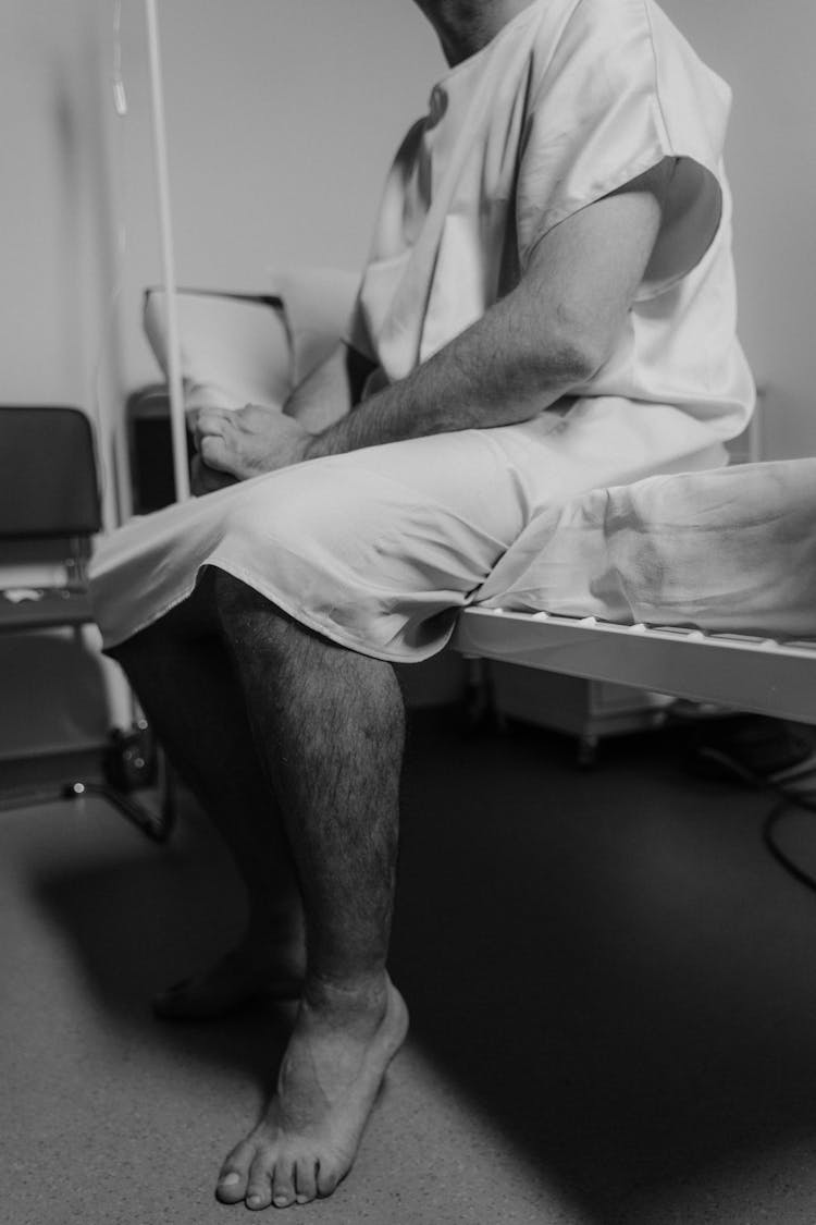 Unrecognizable Man Sitting On The Hospital Bed