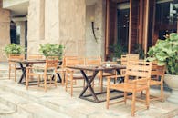 户外咖啡厅区配有木制桌椅，点缀着郁郁葱葱的绿植，显得格外优雅