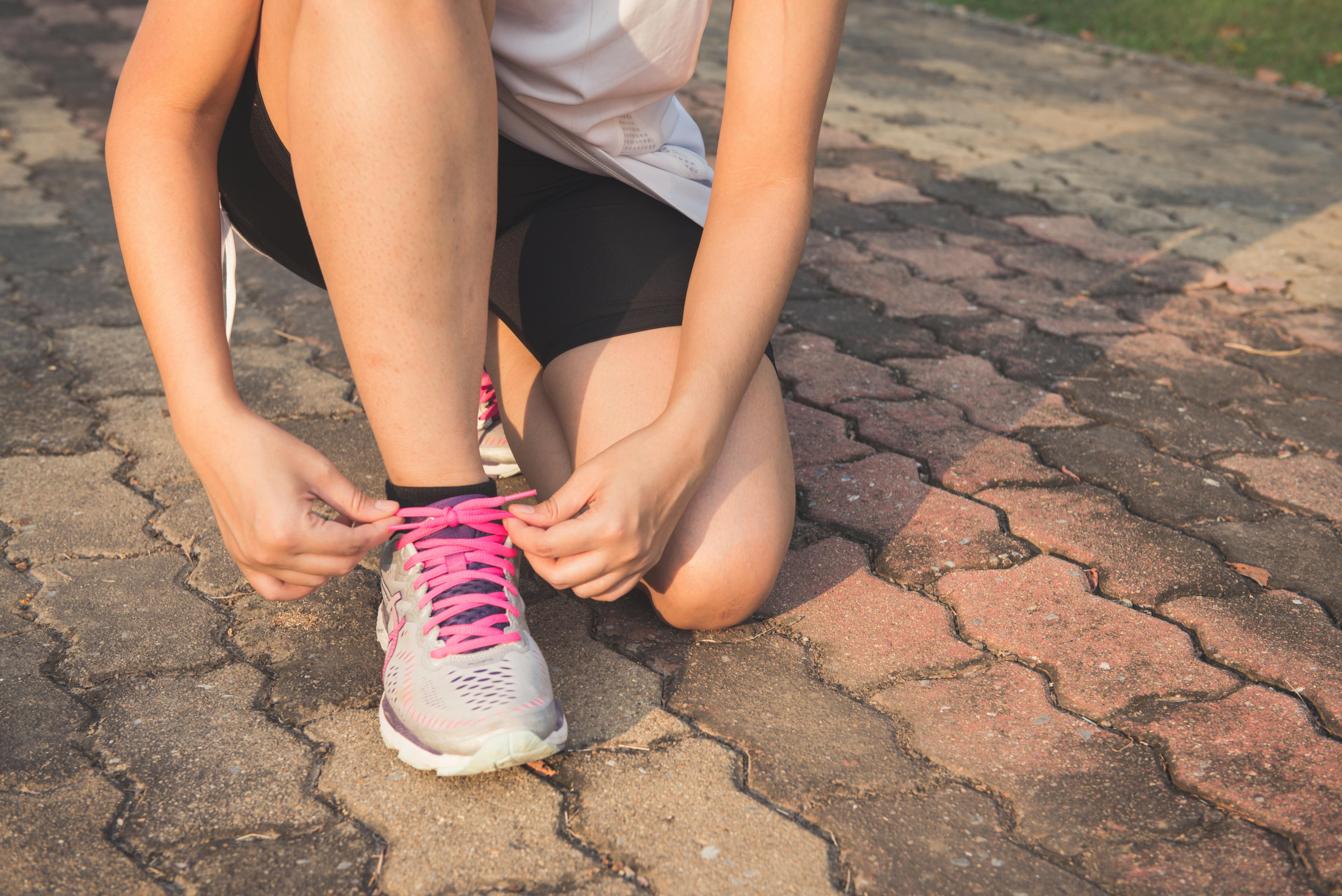 A woman lacing up her shoe. | Source: Pexels