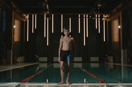 Shirtless Boy Standing at the Poolside