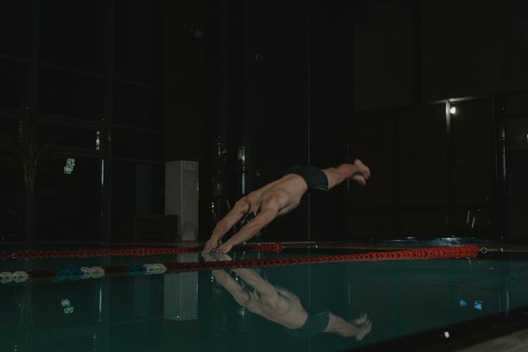 A Man Diving On The Swimming Pool