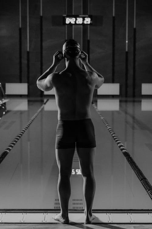 A Swimmer Standing by the Swimming Pool 