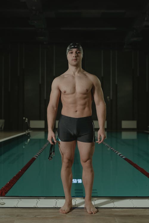 Topless Man Wearing Swimming Trunks and Swimming Cap