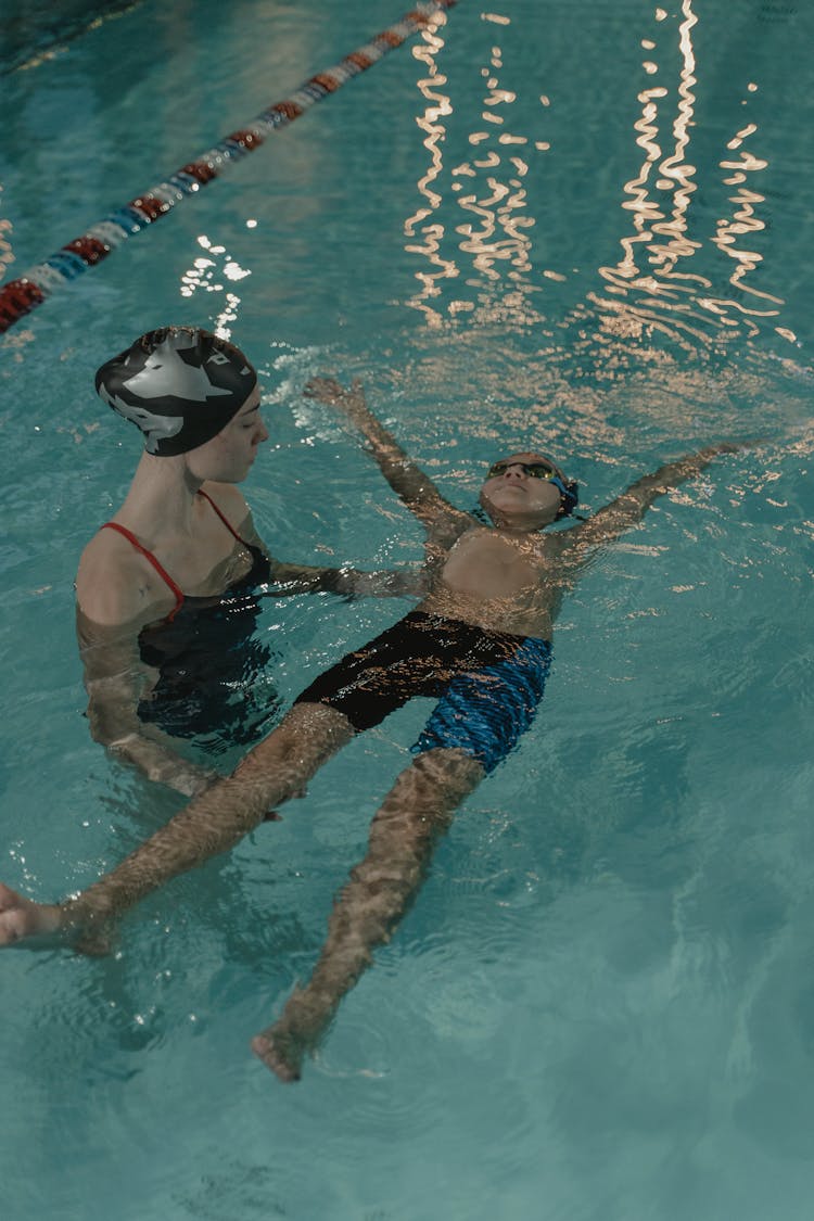 Woman Teaching A Child On How To Swim