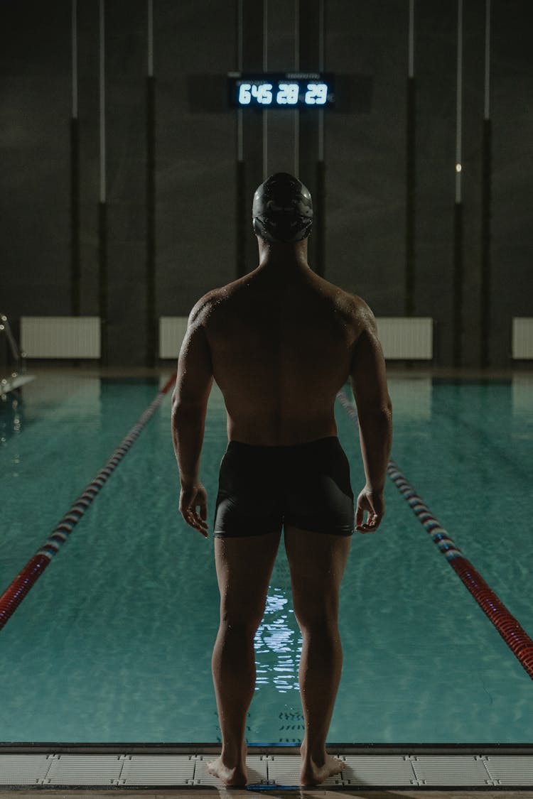 Man In Black Shorts Standing On Swimming Pool