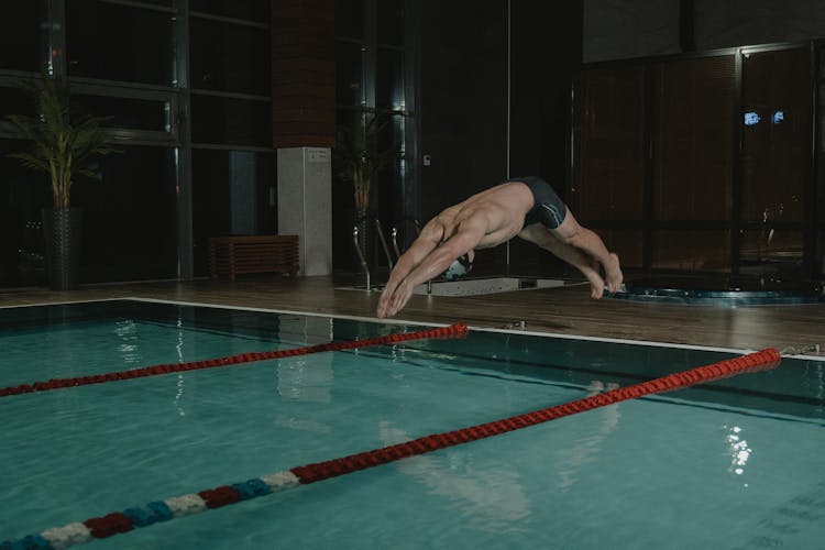 Man In Black Trunks Diving In The Swimming Pool