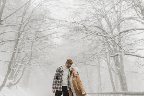 站在雪地上的棕色外套的女人