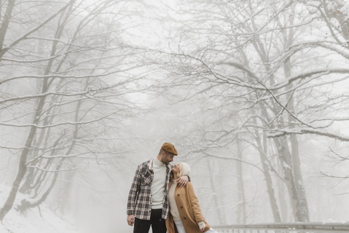 站在雪地上的棕色外套的女人