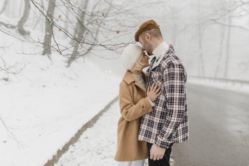 站在雪地上的棕色外套的女人