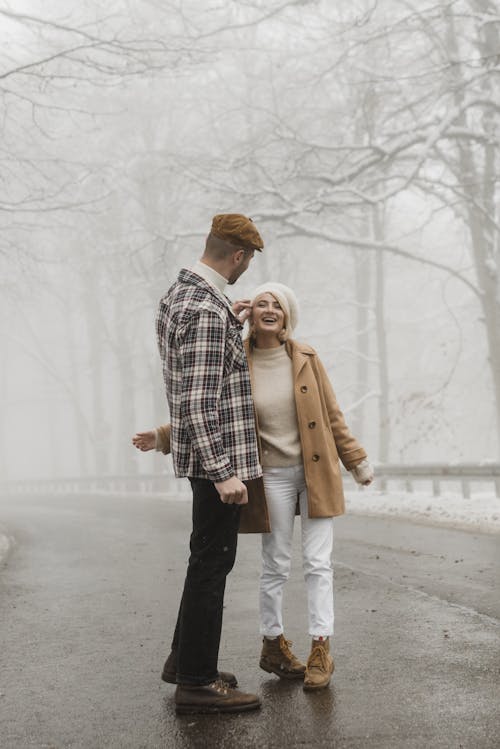 Homme En Manteau Marron Debout à Côté D'une Femme En Manteau Marron