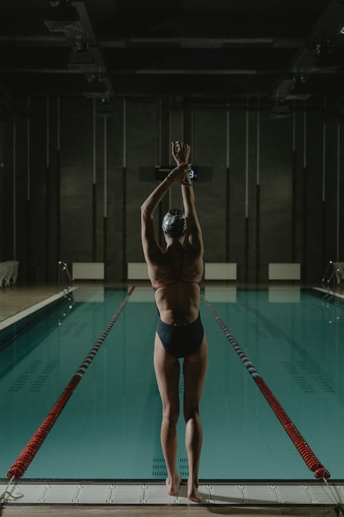 Back View of Woman Stretching Her Body on the Poolside