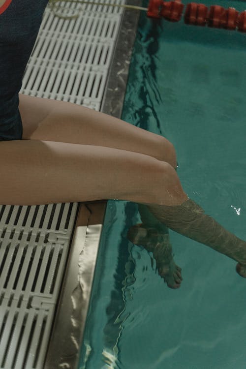 Person's Legs Dipped in Swimming Pool