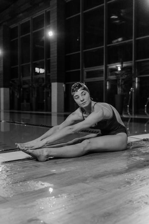 Monochrome Photo of Woman Stretching Her Body on the Poolside