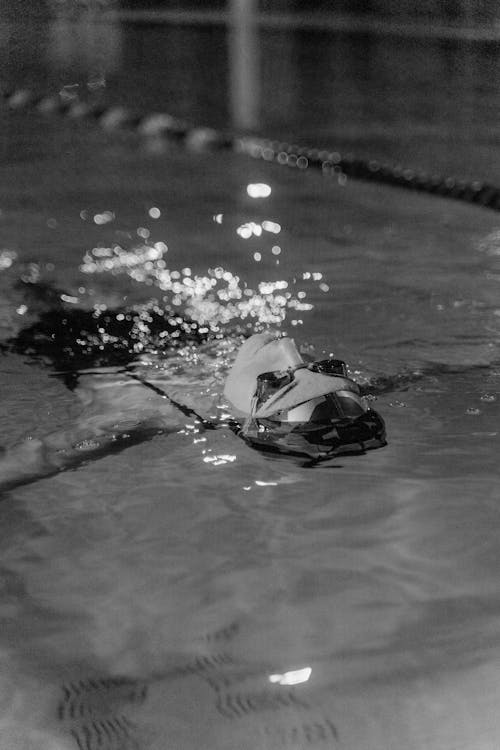 Grayscale Photo of a Broken Glass on a Wet Floor