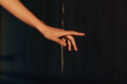Free A graceful hand reaching out, highlighted against a dark background, evokes a sense of curiosity and exploration. Stock Photo