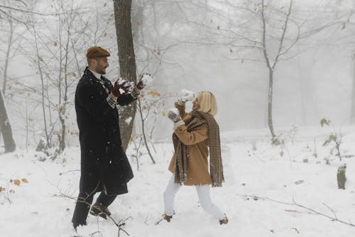Free Sweet Moments of Romantic Couple Playing in the Snow Stock Photo