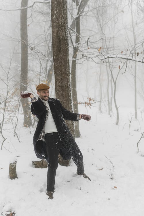 Man in Winter Clothes Having Fun Playing in the Snow