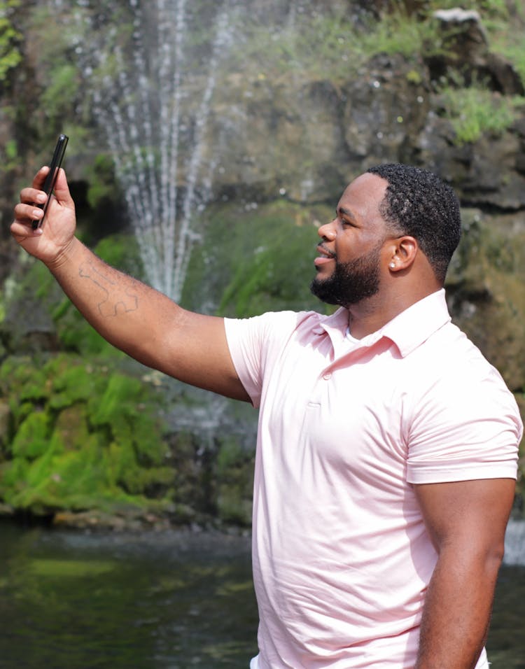Man In Pink Polo Shirt Taking A Selfie