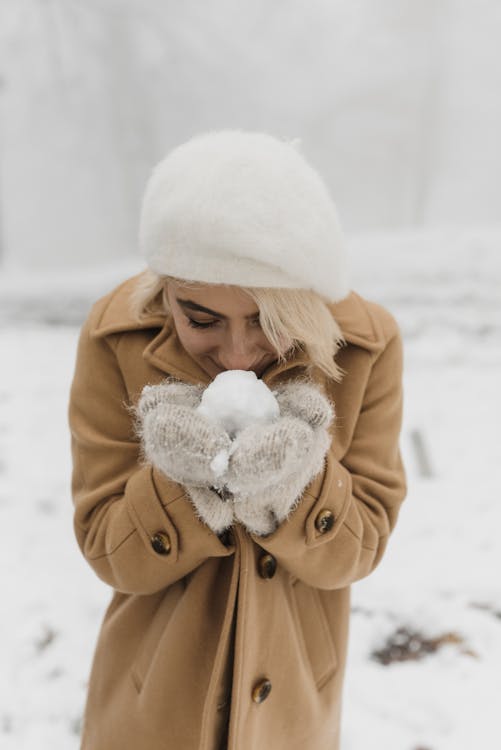 Woman in Brown Coat Holding Snowball