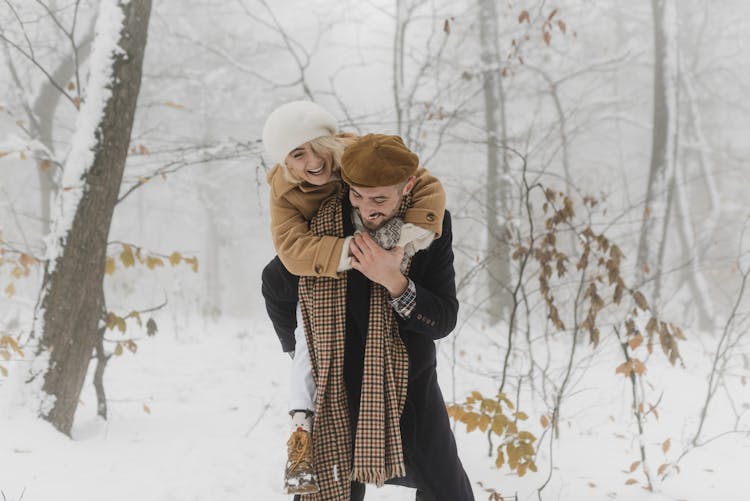 Man In Black Coat Carrying A Woman On His Back