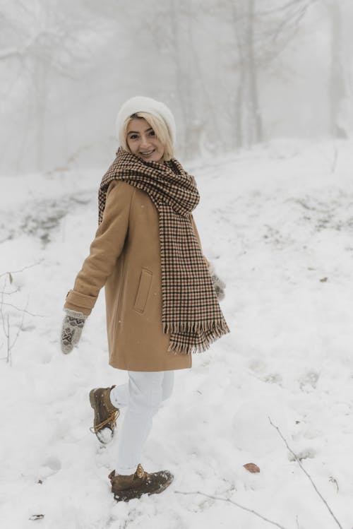 Wanita Berbaju Coklat Berdiri Di Atas Tanah Yang Tertutup Salju
