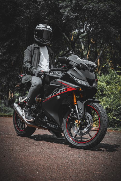 Free A man on a Yamaha sport motorcycle posing in a forested area. Perfect for adventure themes. Stock Photo