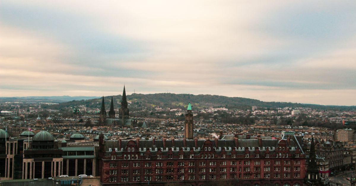 Aerial view of Edinburgh showcasing its historic architecture under a cloudy sky.