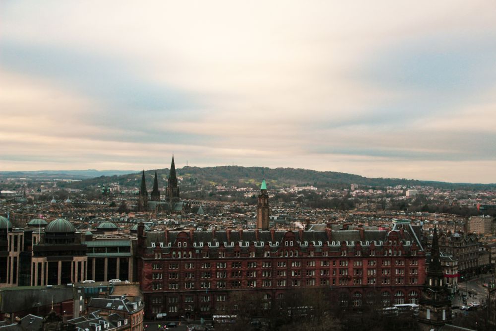 Aerial view of Edinburgh showcasing its historic architecture under a cloudy sky.