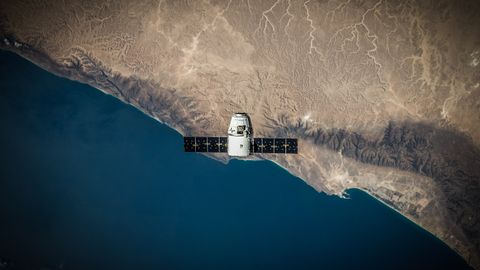 A satellite hovering above Earth's coastline, captured from space.