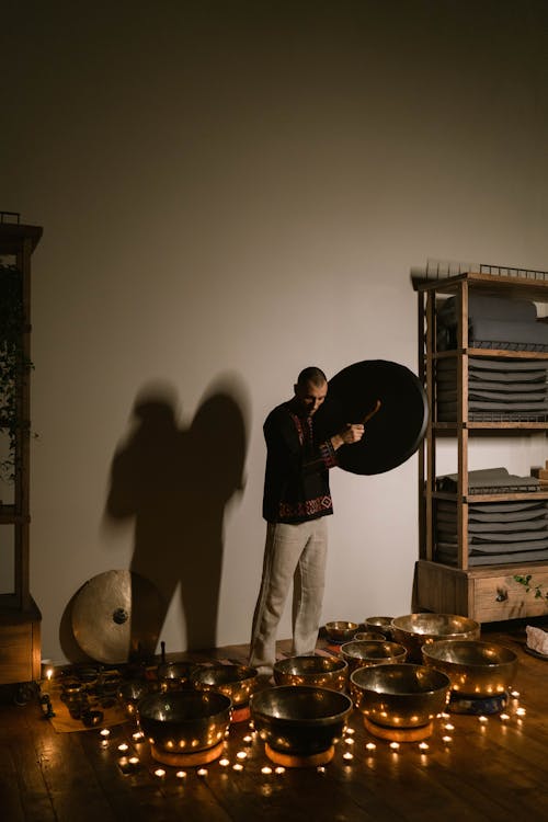 A Man Standing Beside the Singing Bowls