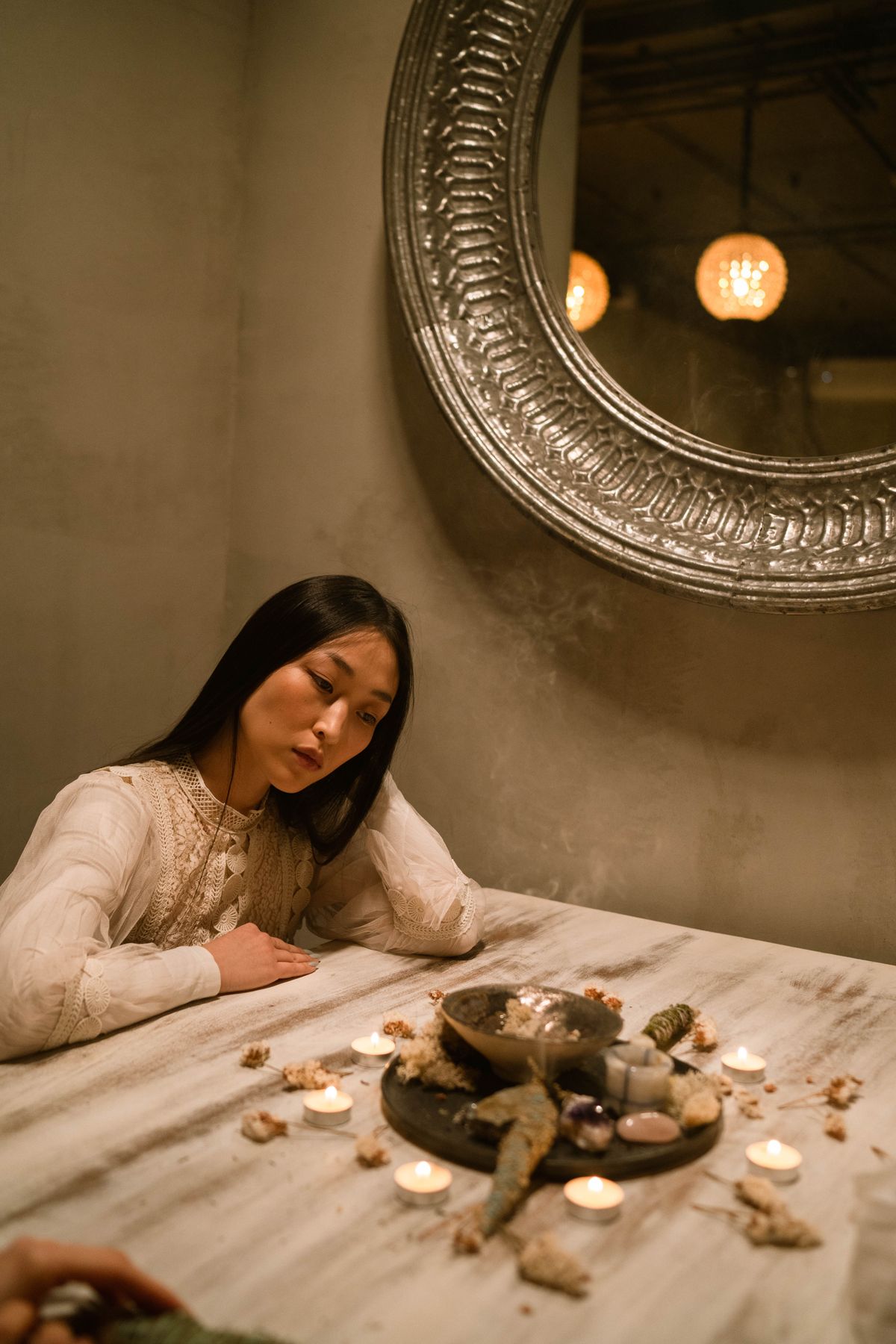 Mulher em ambiente contemplativo com velas e cristais