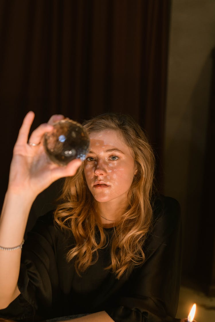 A Woman Holding A Crystal Ball 