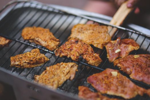 Close-up of seasoned pork chops grilling on an outdoor barbecue. Perfect for summer cookouts.