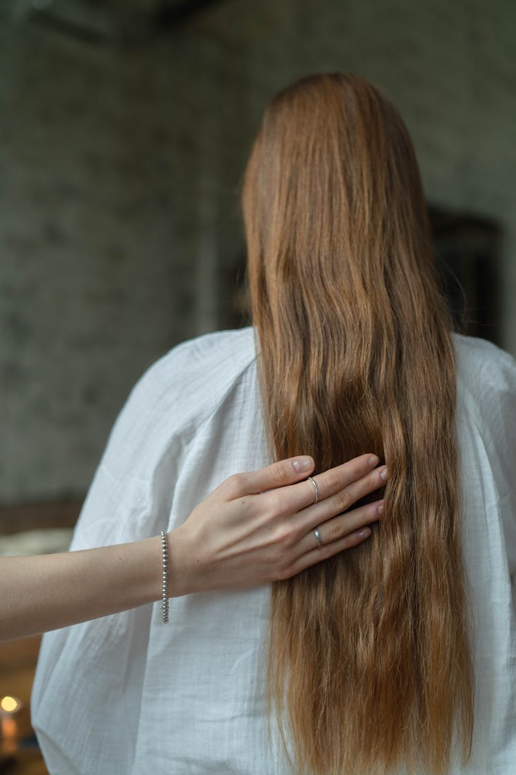 A Person Touching A Person's Long Hair