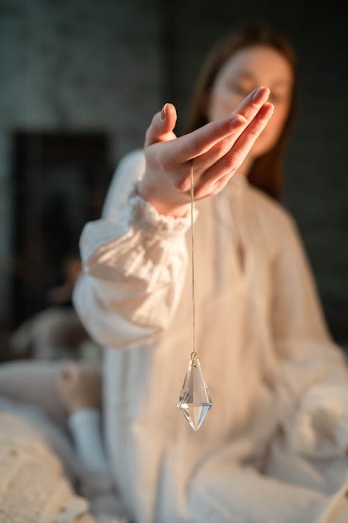 Person Holding Clear Glass Pendant
