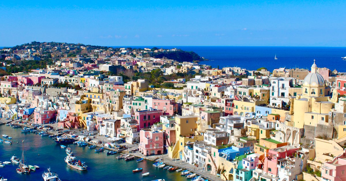 Vibrant pastel houses lining a harbor, Procida Island Italy