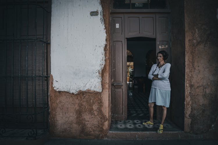 Confident Ethnic Woman At Door Of Old Building