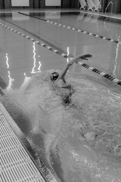 Free Dynamic black and white image capturing a swimmer mid-stroke in a pool, showcasing athletic prowess. Stock Photo