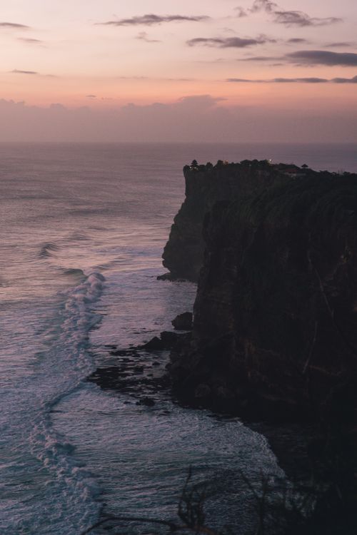 Free A breathtaking view of the Uluwatu cliffs during sunset in Bali, Indonesia, showcasing natural beauty and ocean waves. Stock Photo
