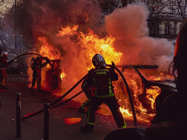 Firemen Extinguishing A Blazing Car Fire