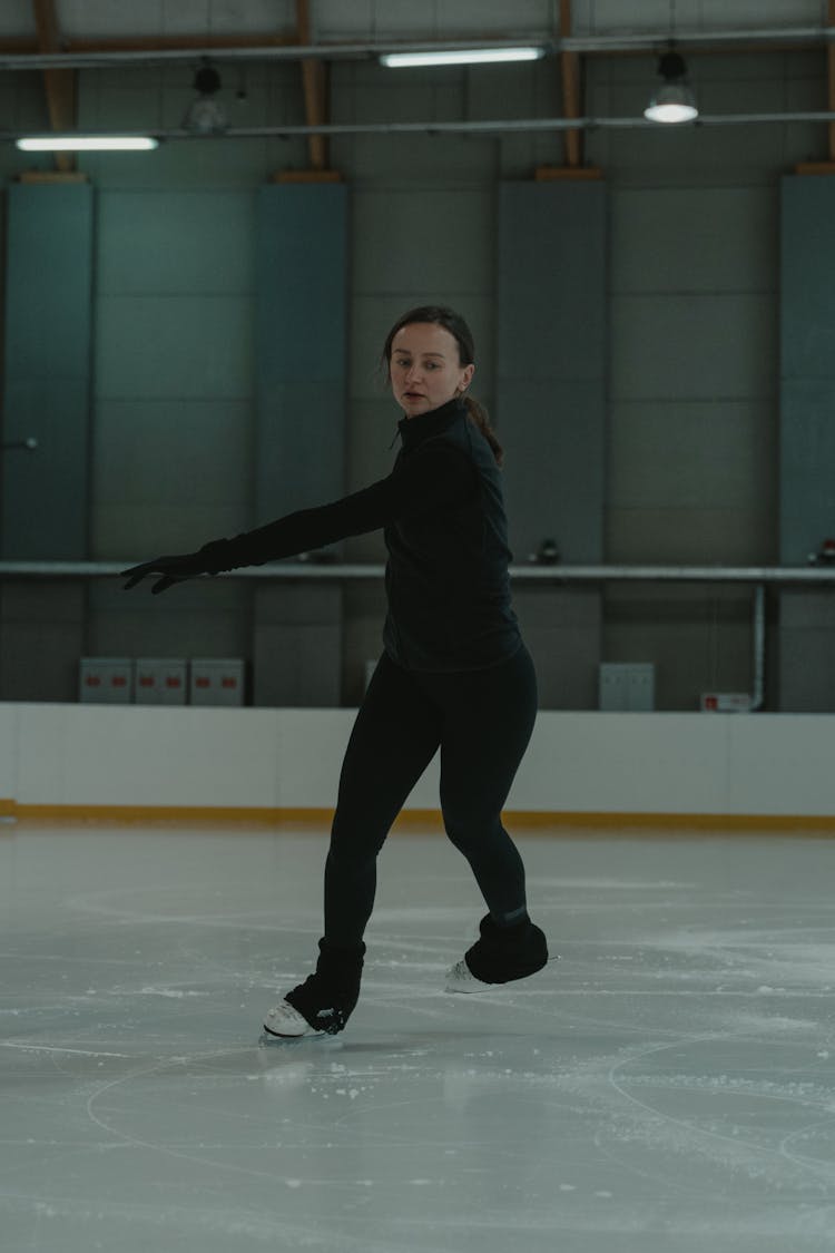 Woman In Black Jacket And Black Pants Doing Indoor  Ice Skating