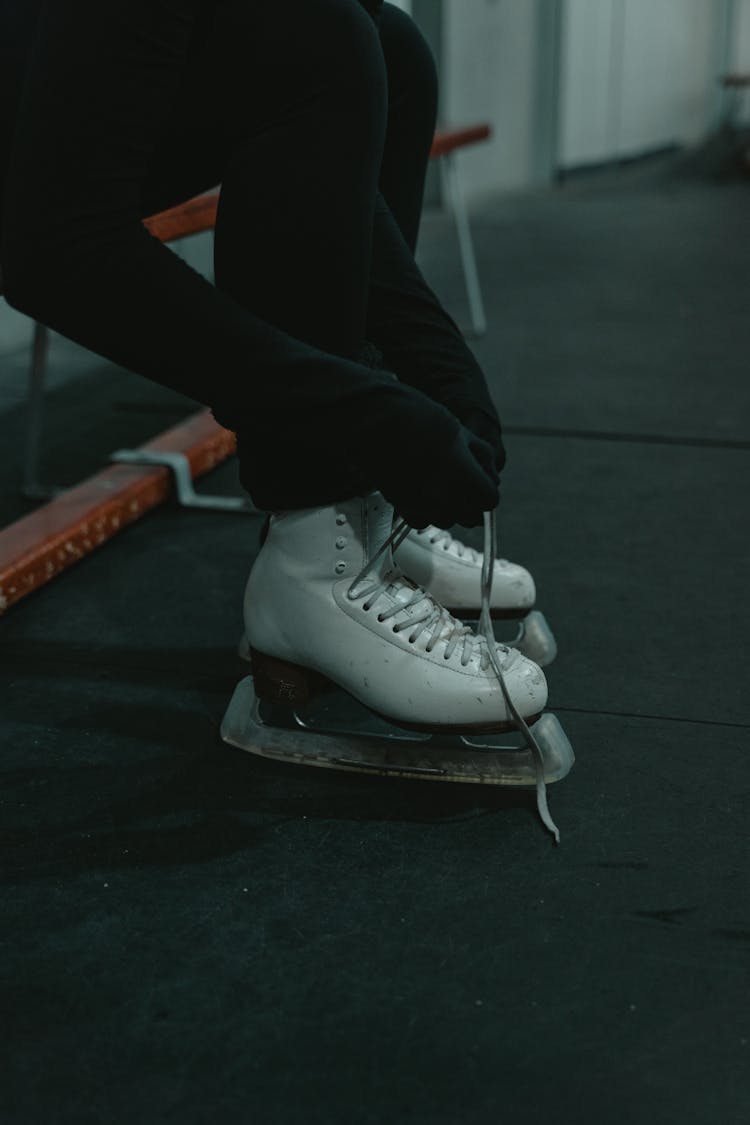 Person Tying Ice Skating Shoes