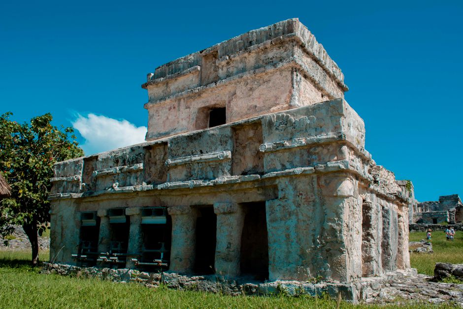 Explore the ancient ruins of Tulum, showcasing Mayan architecture under a bright blue sky.