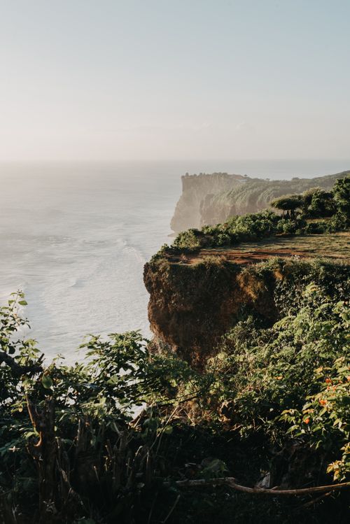 Free Explore the stunning coastline cliffs of Bali, Indonesia, with lush greenery and crashing waves. Stock Photo