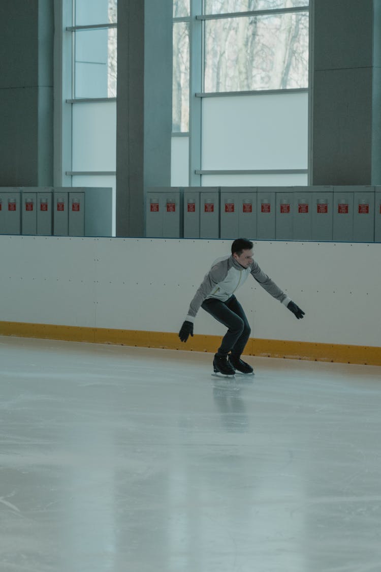 Man In Gray Long Sleeve Shirt And Black Pants Doing Ice Skating