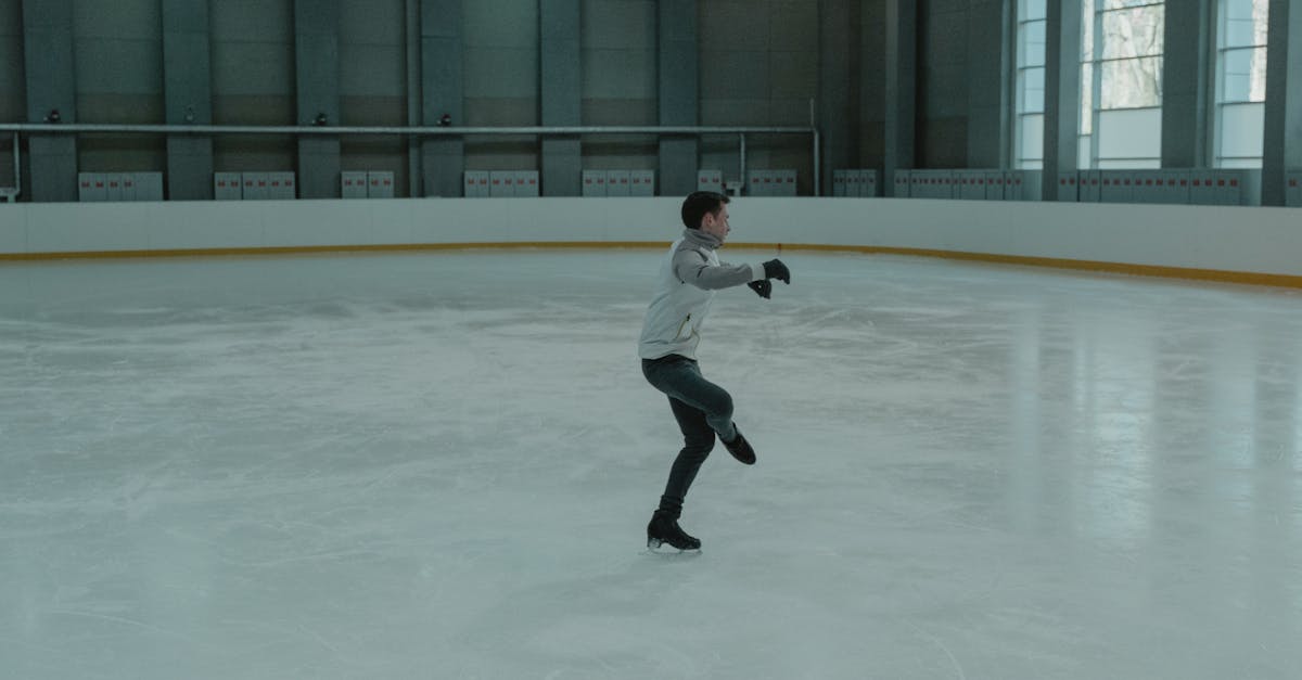 Man in White Long Sleeve Shirt and Black Pants Playing Ice Hockey