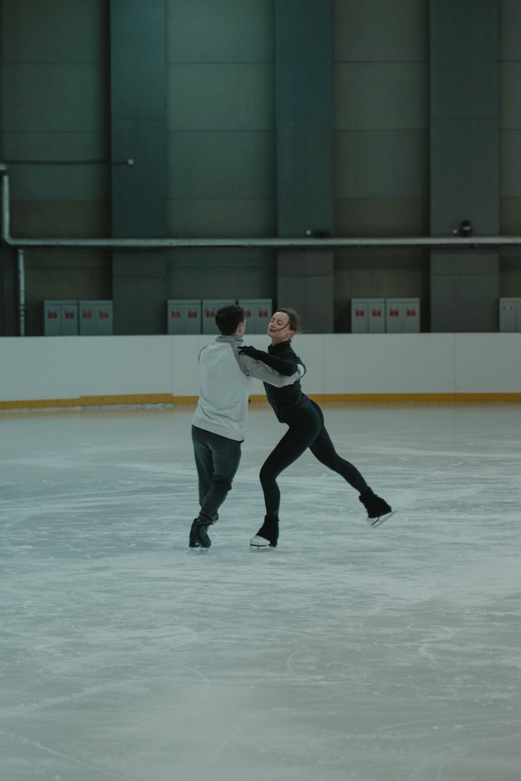 Man And Woman Dancing In The Ice Rink Wearing Ice Skating Shoes 