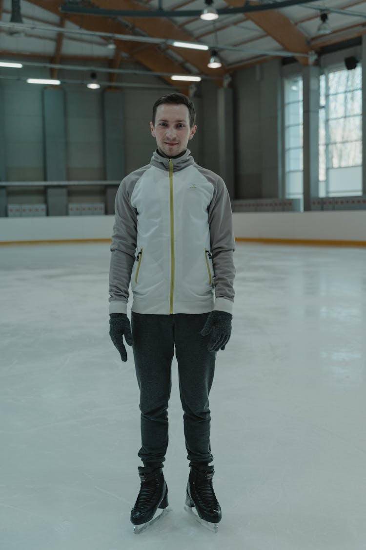 Man In Gray Zip Up Jacket And Black Pants Standing On Ice Rink 