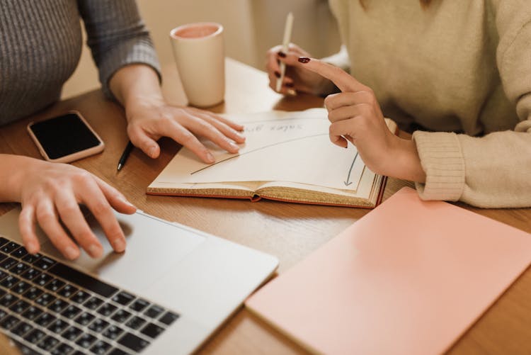 Close-up Of Women Working On Laptop Sitting At Desk